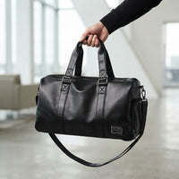 Sac de voyage homme en simili cuir, porté à la main